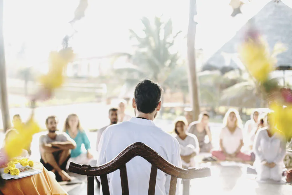 Clase al aire libre: el profesor, de espaldas, frente al grupo de alumnos